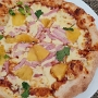 01.04.2024 - Hawaiian Pizza im Wolfgang Puck Kitchen im Airport in Hongkong. - Hoisin BBQ Sauce, Mozzarella Cheese, Roasted Pineapple, Smoked Ham, Cilantro - 168 HK$