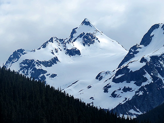 Hohe, mit viel Schnee bedeckte Berge leuchten im Hintergrund. Hohe, mit viel Schnee bedeckte Berge leuchten im Hintergrund.