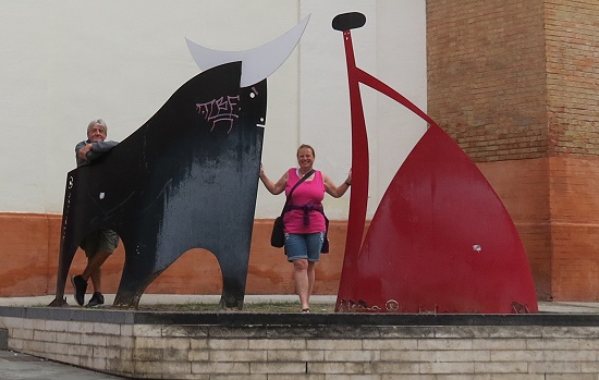 Kunstwerk am Eingang der Arena plus 2 Touristen