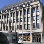 1921 eröffnete das erste Warenhaus Bochums mit 31 Schaufenstern und 64 Verkaufsabteilungen. Über dem Haupteingang an der Kortumstraße grüßt der Gott Merkur als Beschützer des Handels die Kunden, ihm zur Seite pflanzt und erntet die Landwirtschaft, am Horizont kreuzt ein Handelsschiff. Das Relief schuf der Künstler Johannes Knubel.<br />7.8.2022<br />Bekannt geworden ist das Haus durch die Fernsehserie "Der grosse Bellheim"