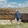 William Bodey hatte 1859 an dieser Stelle Gold gefunden. Er verschwand auf einem Einkaufsausflug, bei dem er neue Materialien und Lebensmittel holen wollte in einem Schneesturm. Seine Familie jedoch gründete die Stadt Bodie und begann 1861 mit dem Goldabbau. Die geänderte Schreibweise war beabsichtigt, um eine falsche Aussprache als "Body" zu vermeiden.<br />Seit 1962 wird Bodie im vorgefundenen Zustand konserviert und ist heute ein State Park. Es sind noch ca. 170 Gebäude vorhanden, u. a. die Kirche, die Schule, eine Bar mit alten Flaschen auf der Theke und ein Laden. Dank der geringen Luftfeuchtigkeit blieben viele Gebäude und Gerätschaften relativ gut erhalten; das Ensemble gilt als besterhaltene Geisterstadt der USA.<br /><br /><br />Besucht am 3.6.2009