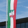 Das Landeswappen vereint die Wappenbilder der drei Landesteile: den Rhein für das Rheinland, das Sachsenross für Westfalen und die Lippische Rose für das 1947 hinzugekommene ehemalige Land Lippe.