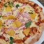 01.04.2024 - Hawaiian Pizza im Wolfgang Puck Kitchen im Airport in Hongkong. - Hoisin BBQ Sauce, Mozzarella Cheese, Roasted Pineapple, Smoked Ham, Cilantro - 168 HK$
