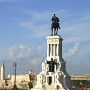 Blick vom Museo de la Revoltuion auf das Castillo del Morro und eine Statue von Maximo Gomez.<br />Er gehörte zu den wichtigsten militärischen Führern der kubanischen Unabhängigkeitsbewegung 1868-1898 gegen die spanische Kolonialmacht. Als oberster Befehlshaber der Revolutionsarmee gelang es ihm in der dritten Phase des Unabhängigkeitskrieges 1895-1898, die auf Initiative des kubanischen Revolutionärs und Dichters José Martí eingeleitet wurde, die spanischen Kolonialtruppen in die Defensive zu drängen.<br />Der militärische Erfolg der Vereinigten Staaten 1898 im Spanisch-Amerikanischen Krieg war unter anderem möglich, weil die spanische Kolonialmacht durch den langen Guerillakrieg unter der Führung von Máximo Gómez und Antonio Maceo bereits entscheidend geschwächt war.<br /><br />Trotz seines hohen Ansehens lehnte er es stets ab, in der von den USA dominierten Kubanischen Republik ein politisches Amt zu bekleiden. Im Gegensatz zu einigen anderen Führern der Unabhängigkeitsbewegung versuchte er nie, Kapital aus seinem Prestige zu schlagen und starb als armer Mann.