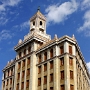 Edificio Bacardi<br />Um 1930 hat sich die Firma Bacardi an der Misiones angespiedelt. Den Artdeco-Turm krönt die Fledermaus, die sich auf jeder Bacardi-Flasche wiederfindet.<br />Die Familie Bacardi unterstützte den Kampf der Revolutionäre gegen den Diktator Fulgencio Batista. Die positive Haltung änderte sich jedoch, als sich der pro-sowjetische Kurs von Ernesto Che Guevara durchsetzte und die diktatorischen Tendenzen Castros klar wurden.<br />Nach ihrer entschädigungslosen Enteignung am 14. Oktober 1960 auf Kuba emigrierte die Familie Bacardi überwiegend und engagierte sich aktiv gegen das herrschende kubanische Regime.