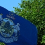 Das Zentrum der Flagge ist ein Schild, welcher die Darstellung eines Elchs abbildet, der vor einer Kiefer ruht. Das Ganze auf einem Feld, das von Wasser und Wald begrenzt wird. Links vom Schild ist ein Farmer abgebildet, der sich auf seine Sense stützt, auf der anderen Seite ein Seemann, der sich an einen Anker lehnt.<br /><br />Über dem Schild ist ein rotes Banner mit dem lateinischen Motto "Dirigo" ("Ich führe") in weißer Schrift, darüber eine stilisierte Darstellung des Nordsterns.<br /><br />Unterhalb des Schilds befindet sich ein blaues Banner mit der Aufschrift "Maine". Motto: Dirigo - I lead<br />Wen? Wohin? Warum?<br />