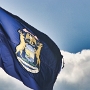 Die Flagge gibt's seit 1911. Zu sehen sind u.a. 3 verschiedene Staatsmotten.<br />auf einem roten Band - "One Nation Made Up of Many States"<br />auf einem blauen Schild - "I will Defend"<br />auf einem weissen Band - "If You Seek a Pleasant Peninsula, Look Around"