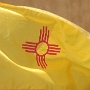 Die Flagge zeigt die Sonne des Zia-Volkes. Die Farben stehen für die spanische Kolonialzeit und finden sich auch heute noch in der Flagge Spaniens.